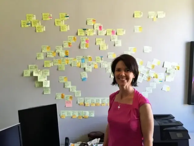 A genealogista Michelle Trostler em frente à "parede de post-its" que ela montou a respeito do caso