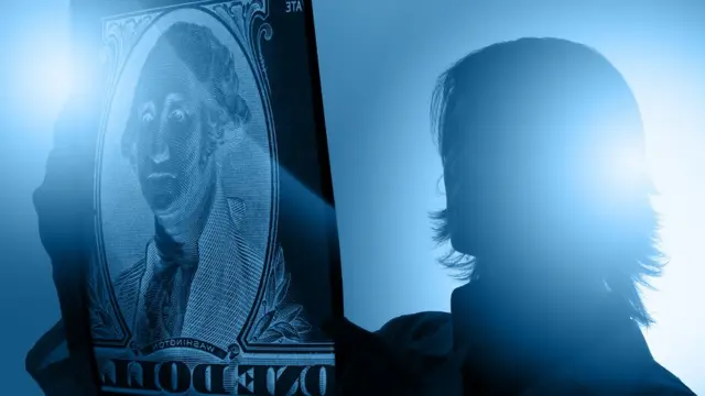 Doctora revisando un rayos x en el que se ve un dólar