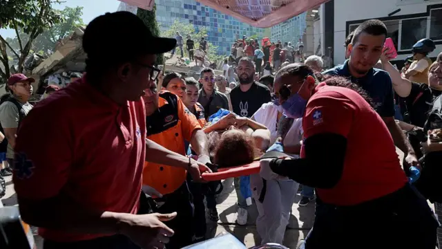 Socorristas carregam uma mulher em uma maca e a transferem para uma ambulância em Cali, durante o terremoto.