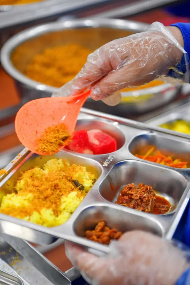 Petugas menyiapkan Makanan Bergizi Gratis (MBG) menu nusantara di sebuah Satuan Pelayanan Pemenuhan Gizi (SPPG).