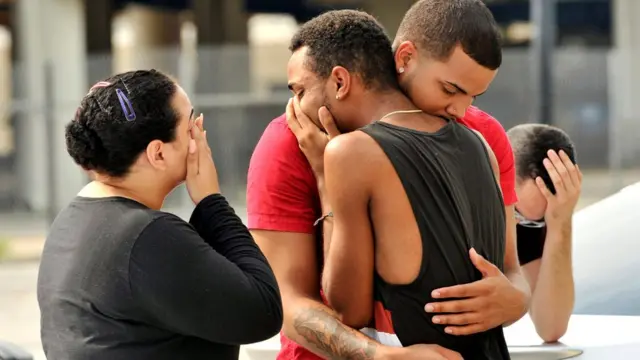 Familiares y amigos de las víctimas de la matanza en el club Pulse, de Orlando, Florida, se congregan frente a la estación de policía que investiga la masacre.
