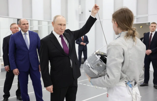 Путін стоїть поруч із дівчиною-фехтувальницею 