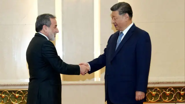 Çin Devlet Başkanı Xi Jinping ve İran dışişleri Bakanı Abbas Arakçi kiremit rengi halıda el sıkışıyorÇin, 15 Temmuz 2025.