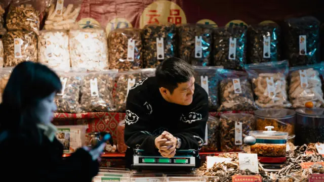 A man sells food in his street booth in Shanghai, China