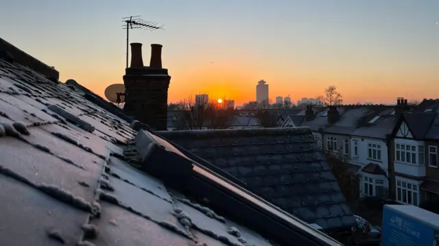 Wschód słońca w Londynie nad dachem pokrytym warstwą szronu