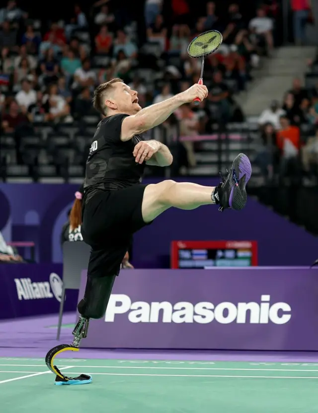 Wojtek Czyz da Nova Zelândia em uma partida de badminton