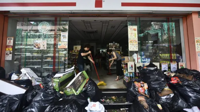 澳門一家被淹水的便利店內店員忙於清理（24/8/2017）