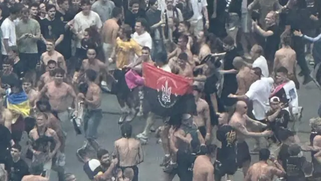 люди на концерті з червоно-чорним прапором