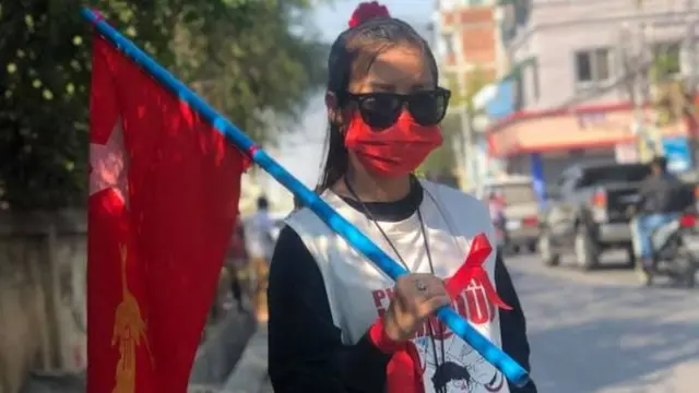 ဖခင်စည်းပေးလိုက်တဲ့ လက်ပတ်နီနဲ့ အလံကိုင်ဆောင်ထားတဲ့ ကြယ်စင်