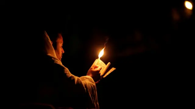 An Ethiopian Orthodox pilgrim reads the Bible during the Christmas Eve celebration in Bete Mariam (House of Mary) monolithic Orthodox church in Lalibela, Ethiopia January 7, 2018.