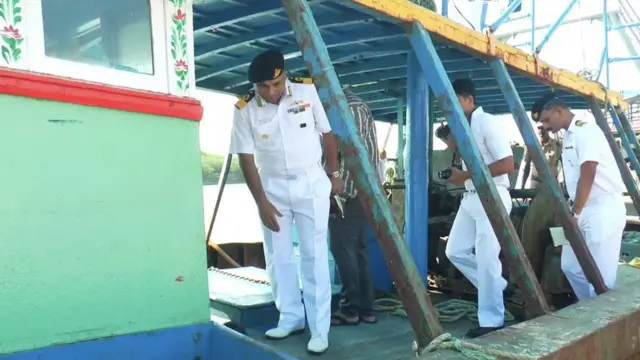 குண்டடி பட்ட படகினை ஆய்வு செய்யும் அதிகாரி.