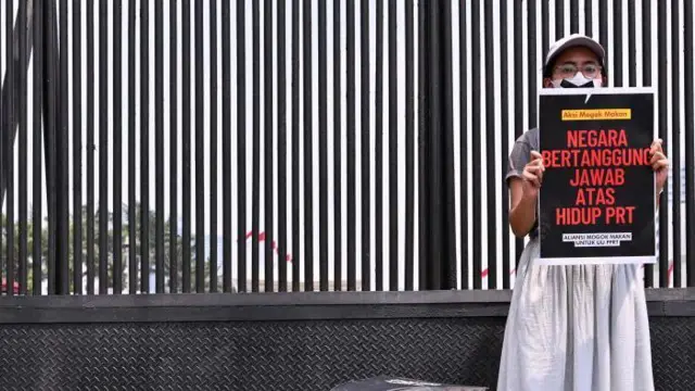 Seorang aktivis mengambil bagian dalam mogok makan di luar gedung parlemen Indonesia di Jakarta pada 14 Agustus 2023, sebagai bagian dari protes yang menuntut anggota parlemen untuk meloloskan RUU yang melindungi pekerja rumah tangga