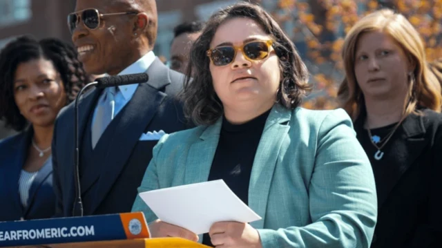 کاتالین کورادی در حال سخنرانی و چند نفر در اطراف او