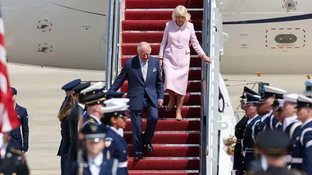 Король Карл III и королева Камилла спускаются по трапу самолета