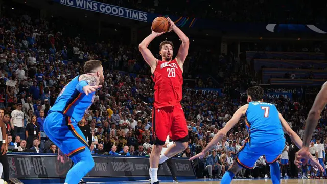 Alperen Şengün elinde topla zıplıyor, karşısında rakip takımdan mavi formalı iki oyuncu