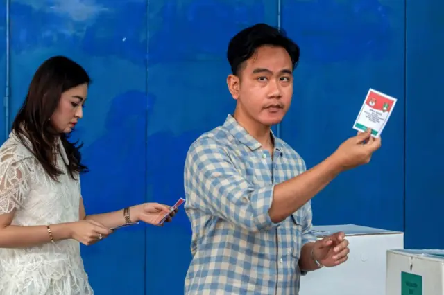 Wakil Presiden Indonesia Gibran Rakabuming Raka (kanan) dan istrinya Selvi Ananda (kiri) menunjukkan surat suara mereka saat memberikan suara pada pemilihan kepala daerah serentak di Solo, Jawa Tengah pada 27 November 2024.