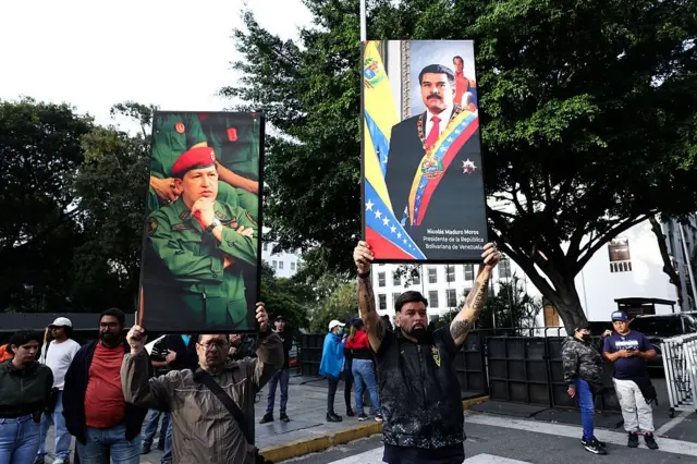 Venezuela'nın başkenti Caracas'ta Hugo Chavez ve Nicolas Maduro posterleri taşıyan eylemciler.