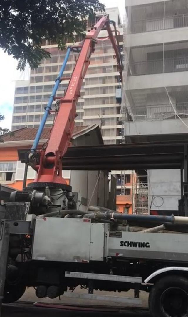 Guindaste ao lado da casa durante obrapreço das loterias da caixaum dos prédios do entorno