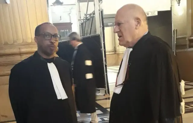 Maître André Martin Karongozi (i bubamfu) aburanira imiryango y'ababuze ababo, ahagararanye na Maître Jean Flamme aburanira Pierre Basabose