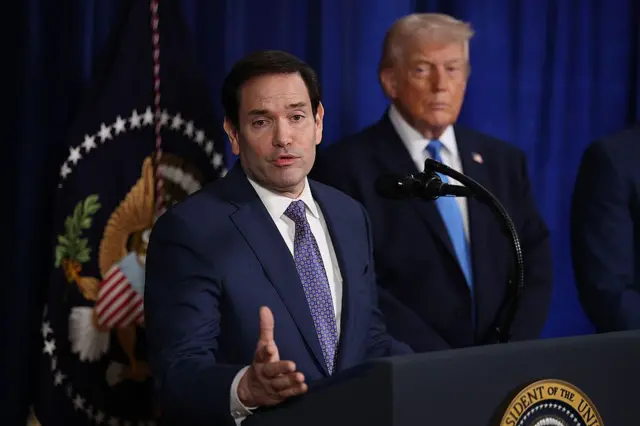 Marco Rubio da una conferencia de prensa. Atrás se ve al presidente Donald Trump.