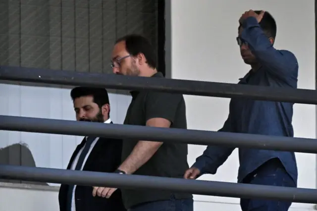 El hijo de Bolsonaro acompañado de funcionarios de la Fiscalía de Brasil.