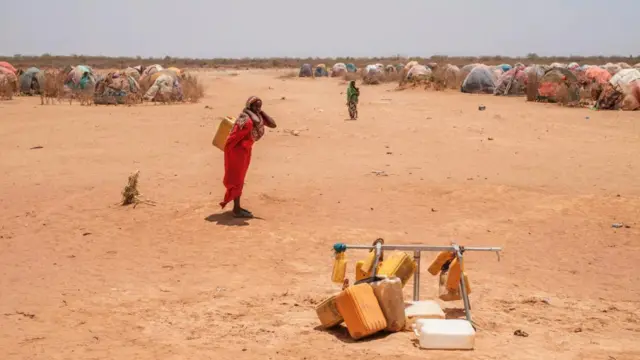 በጎዴ ውሃ በጀርባዋ ተሸክማ የምትሄድ ሴት 