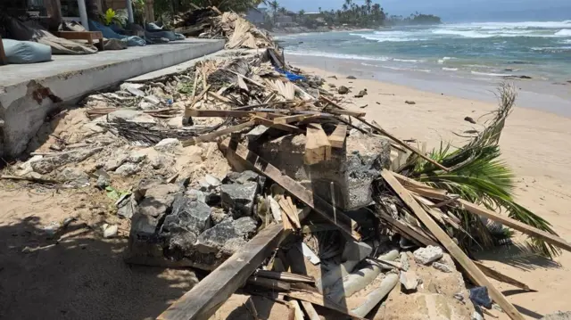 කඩා ඉවත් කරනු ලැබූ ගොඩනැගිලිවල කොන්ක්රීට් ඇතුළු ද්රව්ය වෙරළ තීරය මත ඇති අයුරු