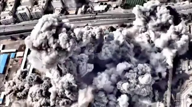 市街地を上空から撮影した映像。巨大な白と灰色の煙が立ち上っている