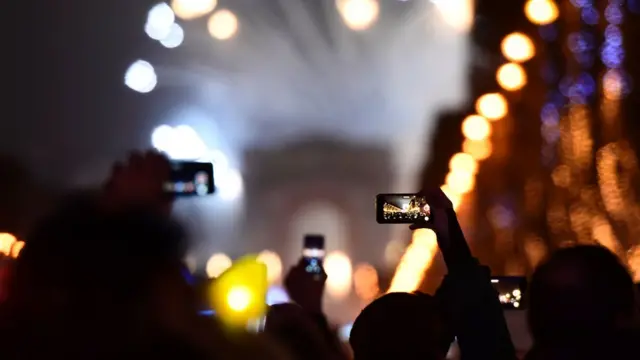 Pessoas filmam queimabonus de 5 aposta ganhafogos com smartphone