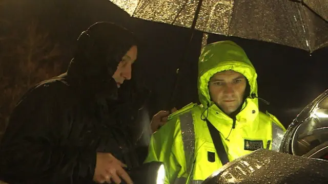 鲍勃·威泽若尔(右）到车祸现场取证。