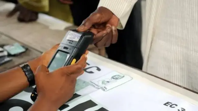 Wani mutum ke anya hannunsa a na'urar tantance masu zaɓe, domin tantance shi