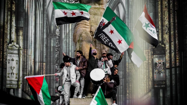Orang-orang membawa bendera oposisi Suriah saat merayakan pengambilalihan Damaskus oleh pemberontak, di Utrecht, Belanda, pada 8 Desember 2024