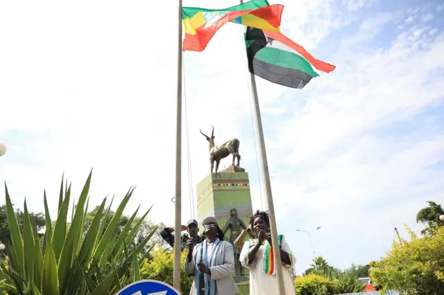 ክልሉን እና የፌደራል መንግሥቱን ሰንደቅ የሚሰቅሉ ሰዎች