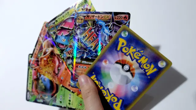 Beyaz bir arka plan önünde, yelpaze şeklinde dizilmiş birkaç Pokémon kartı.