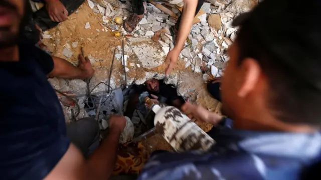 કાટમાળમાં બચી ગયેલી પુરુષને કાઢવાની મથામણ