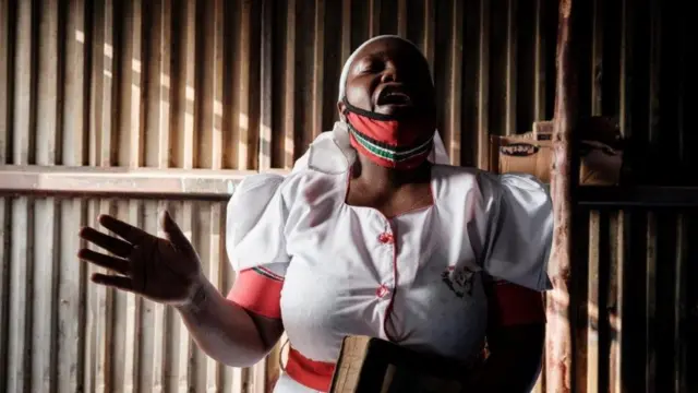 A worshipper of the African Divine Church attends a prayer at their church in the Kibera slum of Nairobi, on July 26, 2020, after Kenya's President allowed places of worship to reopen under strict guidelines to curb the spread of the novel coronavirus (COVID-19).