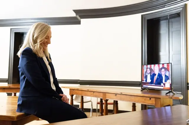 La gobernadora de Virgina escucha el discurso de Trump con una sonrisa en su cara.