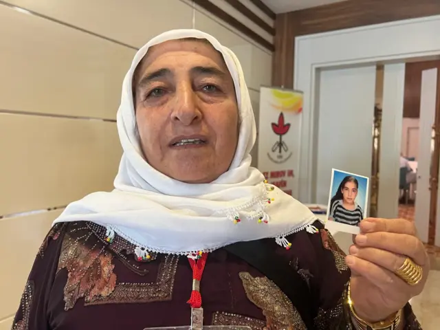 Cemile Çağırga kızı Emine'nin fotoğrafını elinde tutuyor