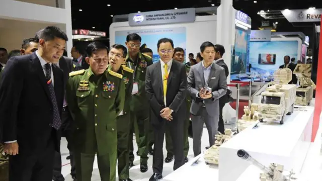  ၂၀၁၉ခုနှစ် ထိုင်းနိုင်ငံမှာကျင်းပတဲ့ စစ်လက်နက်ပြပွဲမှာ ဗိုလ်ချုပ်မှူးကြီးမင်းအောင်လှိုင် နောက်မှာ ကပ်လျက်တွေ့ရတဲ့ နက်ခ်တိုင် အဝါရောင်နဲ့ ဒေါက်တာထွန်းမင်းလတ် 