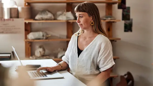 mulher jovem e branca trabalhandosorte esportiva vipfrente a um notebook