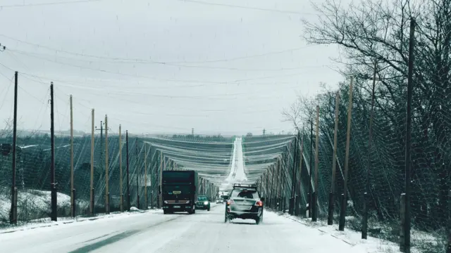 Дорога, накрита великими сітками від дронів, на ній автомобілі