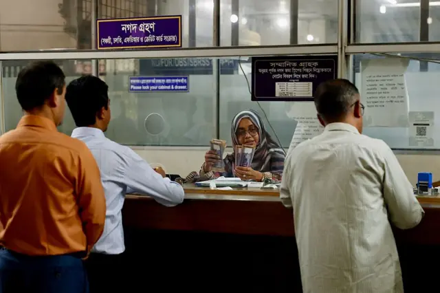 একটি ব্যাংকের কাউন্টারে লেনদেন করছেন গ্রাহকরা