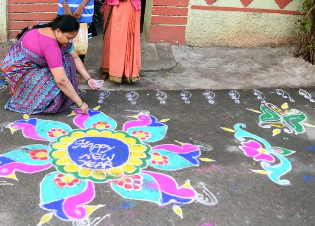 રંગોળી બનાવી રહેલી મહિલા