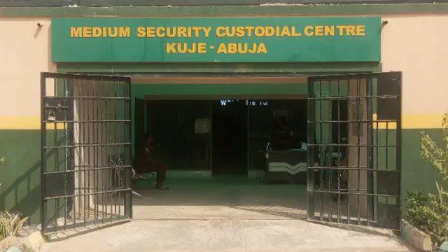 Hoton ƙofar gidan yarin Kuje da ke abuja a buɗe wasu ma'aikata na zaune daga ciki