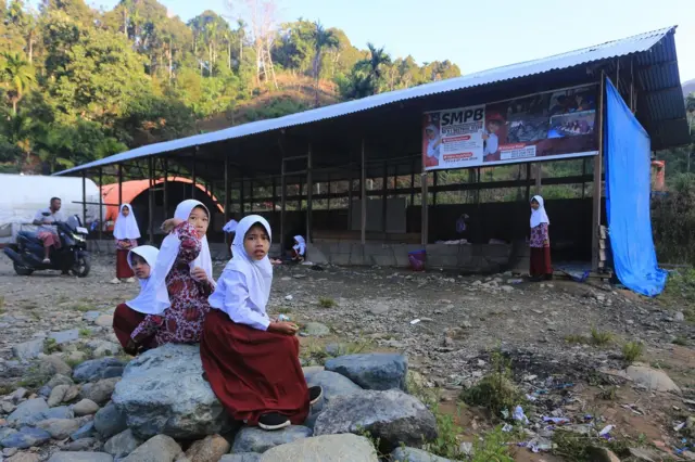 Sejumlah siswa berada di halaman ruang kelas Sekolah darurat Sekolah Dasar Negeri (SDN) 1 Beutong Ateuh Banggalang, Desa Kuta Teungoh, Nagan Raya, Aceh, Kamis (23/7/2026).