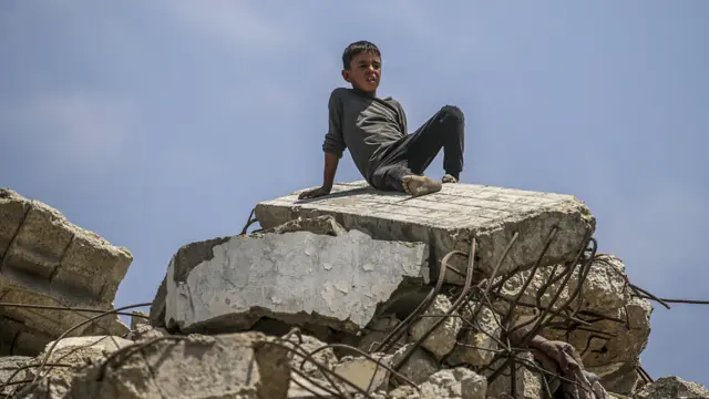 Palestinski dečak sedi na rublji uništene zgrade u severnom delu Pojasa Gaze, 8. avgusta 2025. godine.