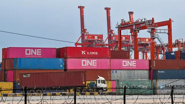 Грузовик перевозит грузовой контейнер в порту Сиануквиля в Камбодже