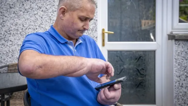 Steven Gallagher uses his mobile phone