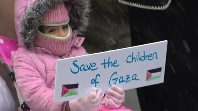 A child at a Chicago rally holds a sign saying 'Save the children of Gaza'