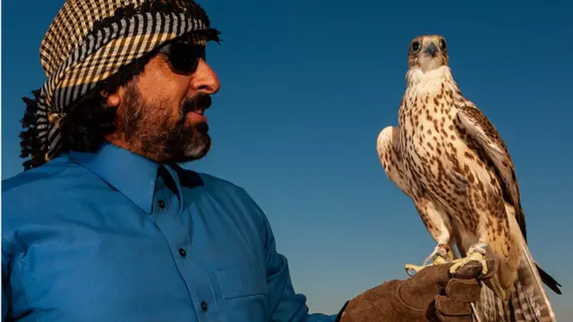 చేతిపై గద్దతో సౌదీవాసి